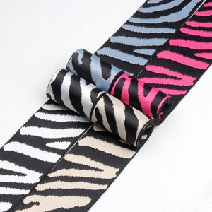 Puede incluir: Cuatro rollos de cinta elástica negra y blanca con estampado de cebra en diferentes colores: blanco, beige, azul y rosa.