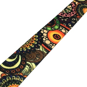 May include: A colorful patterned webbing strap with a black background and bright orange, yellow, green, and blue accents. The pattern features abstract shapes and swirls.