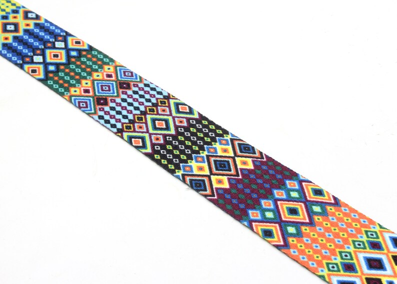 May include: A colorful patterned ribbon with a geometric design featuring squares and diamonds in shades of blue, green, yellow, orange, red, and black.