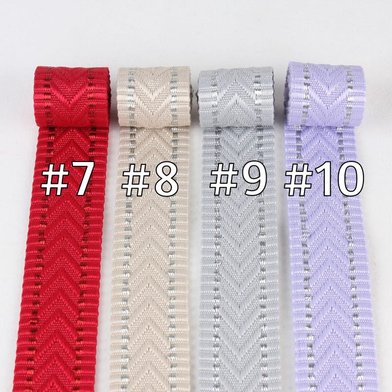 May include: Four samples of ribbon with a chevron pattern. The ribbon is red, cream, gray, and lavender. Each ribbon has a silver thread running through it. The ribbon is labeled #7, #8, #9, and #10.