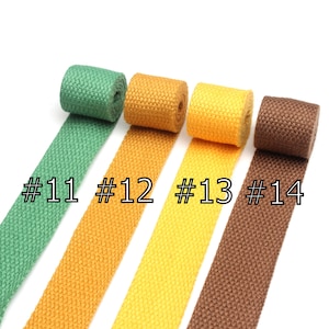 May include: Four rolls of cotton webbing in green, yellow, orange, and brown. The rolls are labeled #11, #12, #13, and #14.