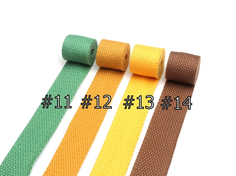 May include: Four rolls of cotton webbing in green, yellow, orange, and brown. The rolls are labeled #11, #12, #13, and #14.