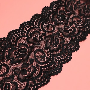 Puede incluir: Borde de encaje negro con un delicado diseño floral. El encaje es suave y flexible, lo que lo hace ideal para agregar un toque de elegancia a cualquier proyecto.