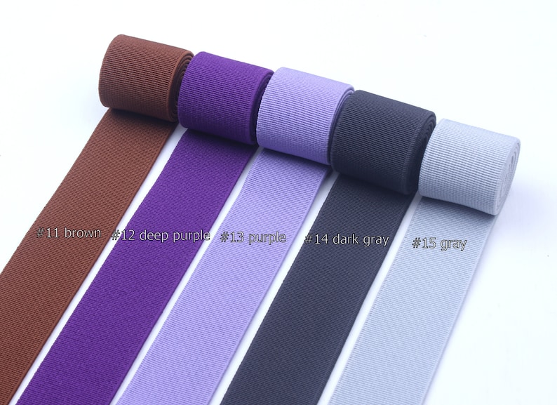 May include: Five rolls of elastic ribbon in different colors: brown, deep purple, purple, dark gray, and gray. The ribbon is labeled with numbers 11 through 15.