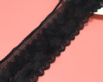 May include: Black lace trim with a scalloped edge. The lace is delicate and has a floral pattern.