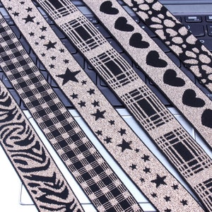 May include: Six different types of black and gold elastic trim with various patterns, including stars, hearts, plaid, and zebra print.