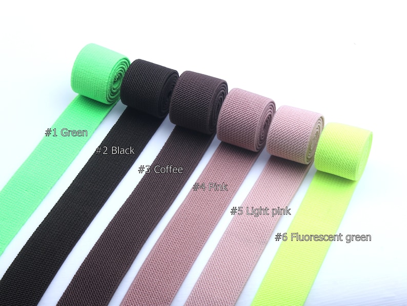 May include: Six different colors of elastic webbing, including green, black, brown, pink, light pink, and fluorescent green. The webbing is arranged in a row, with the colors alternating.