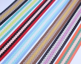 Op de afbeelding: Assortiment van kleurrijke gestreepte geweven lint met een chevron-patroon. De linten zijn in verschillende kleuren, waaronder rood, blauw, bruin, roze en oranje.