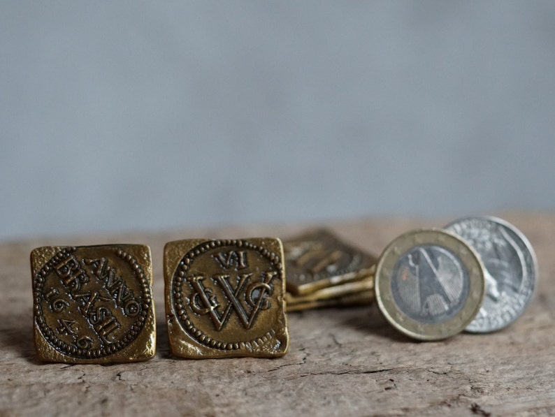 May include: Two antique brass tokens with raised lettering. One token reads "Anno Brasil 16", the other token has a stylized "W" with a crown above it.