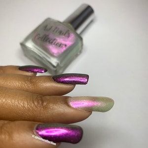 Puede incluir: Una mano con esmalte de u&ntilde;as de color morado oscuro con acabado hologr&aacute;fico. El esmalte de u&ntilde;as es de la colecci&oacute;n AJ Nails.