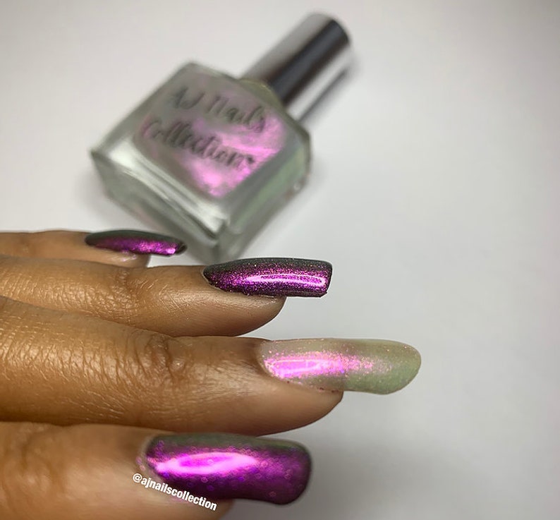 Puede incluir: Una mano con esmalte de u&ntilde;as de color morado oscuro con acabado hologr&aacute;fico. El esmalte de u&ntilde;as es de la colecci&oacute;n AJ Nails.