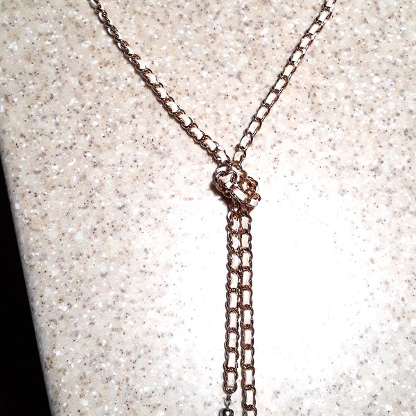 Guess - Copper or Rose Gold Tone Link Knotted Y necklace with tassels and interwoven white ribbon -- hangs 20 inches in length   item A007