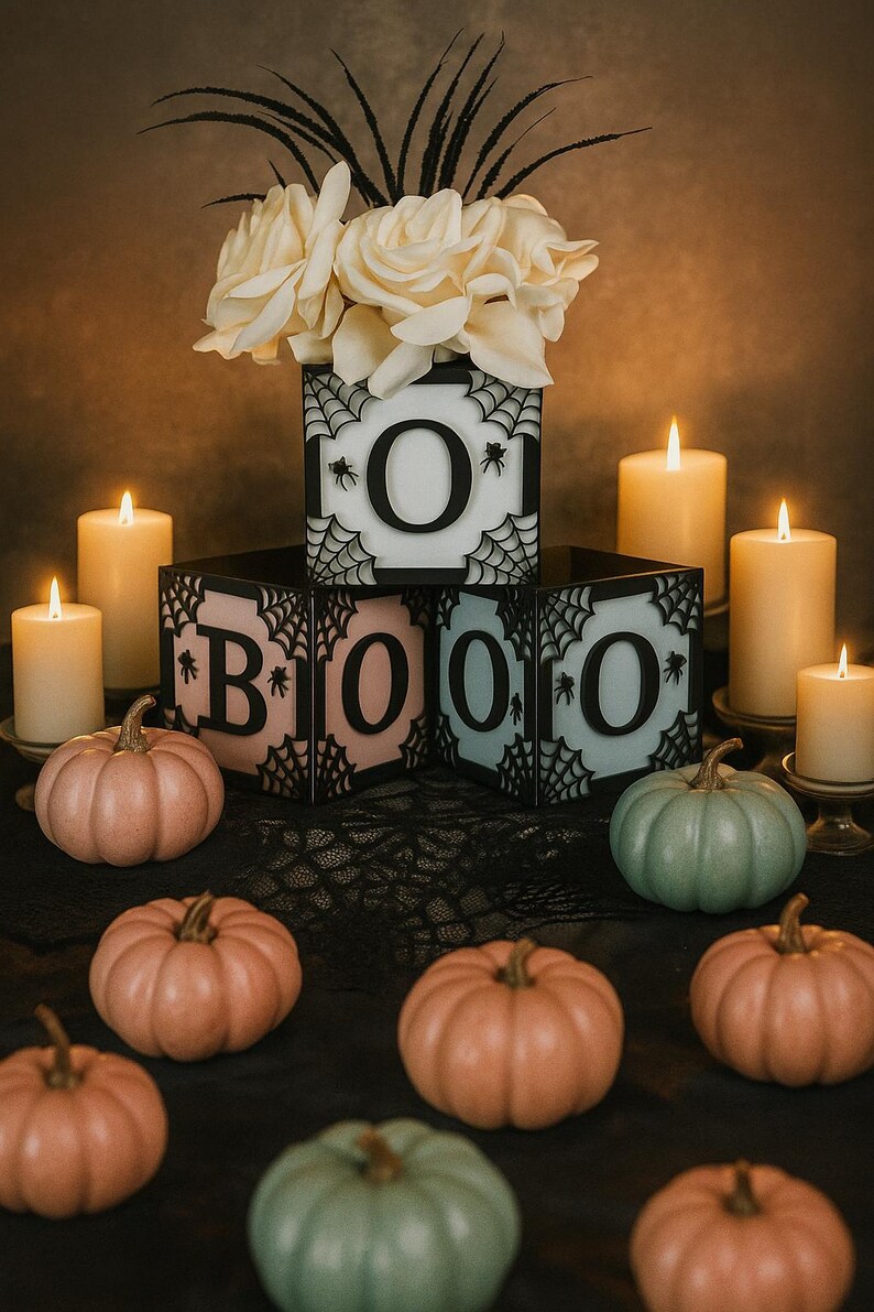 Pode incluir: Uma exibi&ccedil;&atilde;o tem&aacute;tica de Halloween com a palavra "BOO" escrita com blocos iluminados, cada um com um design de teia de aranha e uma letra. A cena inclui ab&oacute;boras e velas acesas, criando uma atmosfera festiva. As ab&oacute;boras s&atilde;o laranja e verdes.