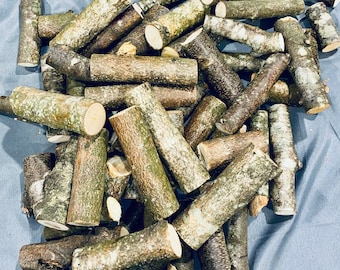 May include: A pile of natural wood sticks, some with bark, in various sizes and shapes. The sticks are arranged in a random pattern, with some overlapping.