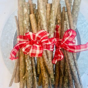 May include: A bundle of brown sticks tied together with two red and white gingham bows.