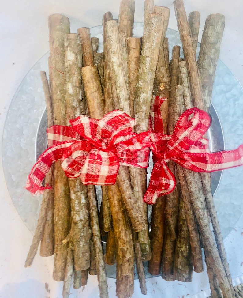 May include: A bundle of brown sticks tied together with two red and white gingham bows.