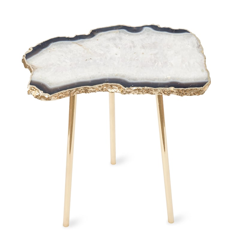 May include: A side table featuring an irregular, geode-inspired tabletop with a white crystalline center, dark gray banding, and a textured gold-tone edge. The table is supported by three slender, polished gold-tone metal legs.