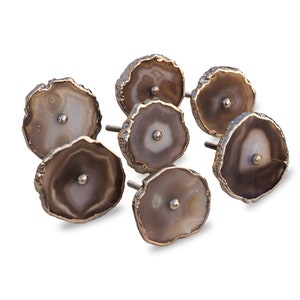 May include: Set of six agate drawer pulls with a gold finish. Each pull features a unique natural agate slice with brown and white patterns.