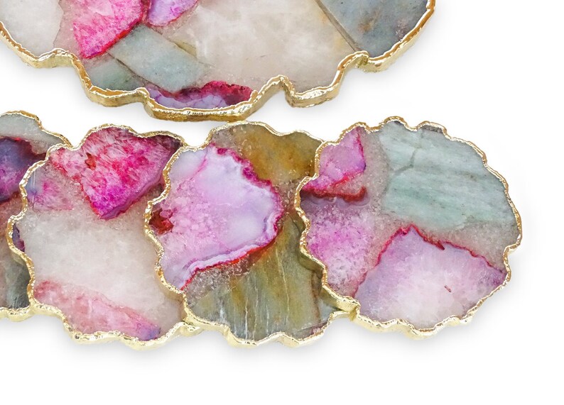 Puede incluir: Juego de cuatro posavasos de &aacute;gata con borde dorado. Cada posavasos presenta un patr&oacute;n veteado &uacute;nico en rosa, blanco y verde.