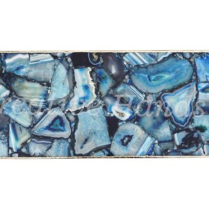 May include: A rectangular blue agate table top with a gold metal frame. The table top is made of many small pieces of agate, each with a different pattern and color.