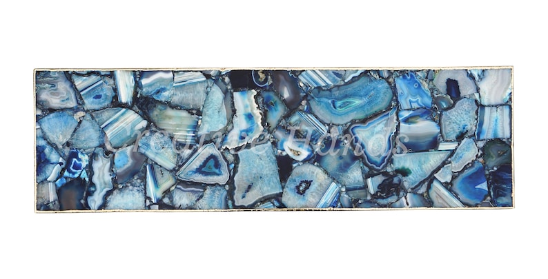 May include: A rectangular blue agate table top with a gold metal frame. The table top is made of many small pieces of agate, each with a different pattern and color.