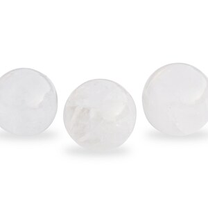 May include: Three white crystal spheres, each with a smooth, polished surface.