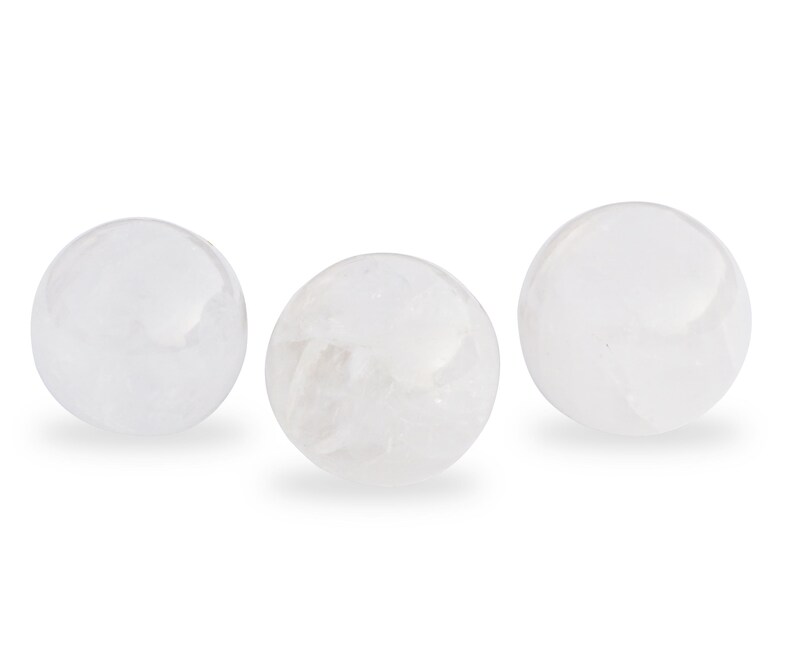May include: Three white crystal spheres, each with a smooth, polished surface.