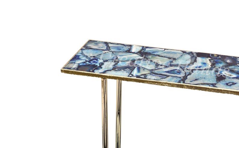 May include: A modern console table with a blue agate top and gold trim. The table has a rectangular top and two chrome legs.