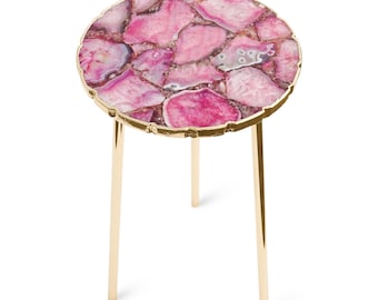 May include: A round side table featuring a tabletop made of pink agate stone slices with a gold-toned metallic edge. The table is supported by three slender, straight gold-toned metal legs that extend downward from the circular stone top.