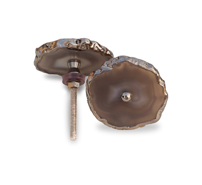 May include: Two agate drawer pulls with a silver finish. The pulls have a natural, irregular shape and a smooth, polished surface.