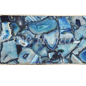 May include: A rectangular tray with a gold metal frame and a blue agate stone surface. The stone is cut into many small pieces and arranged in a mosaic pattern.