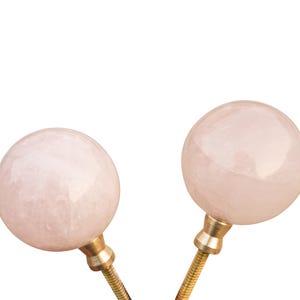 Pu&ograve; includere: Due pomelli rotondi in quarzo rosa rosa con basi in metallo dorato. I pomelli sono lisci e lucidi.