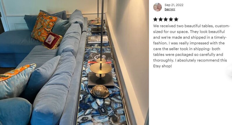 May include: Two custom-sized agate tables with a gold metal stand and a blue velvet sofa with pillows. The tables are made of blue and white agate slices.