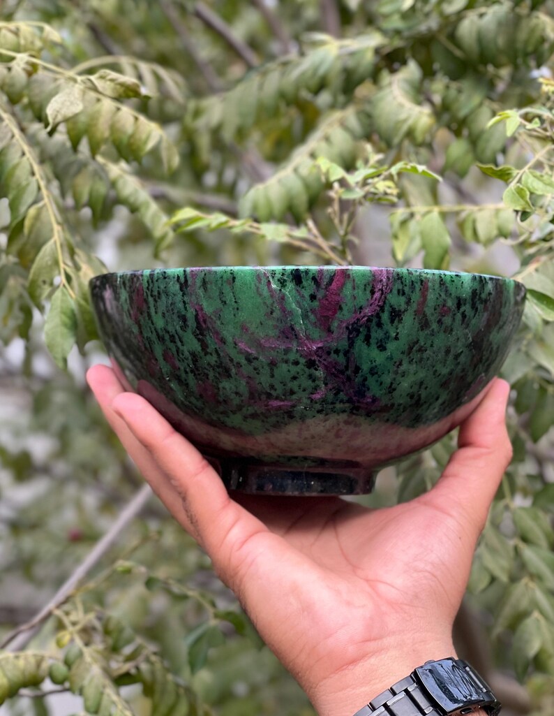 May include: A green and pink bowl made of polished stone. The bowl has a swirling pattern of green, pink, and black.