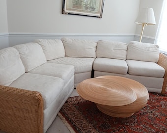 Sofá vintage de bambu com curvas e mesa de vime.