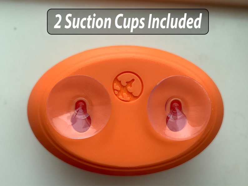 May include: Orange oval-shaped suction cup holder with two clear suction cups and the text "2 Suction Cups Included".