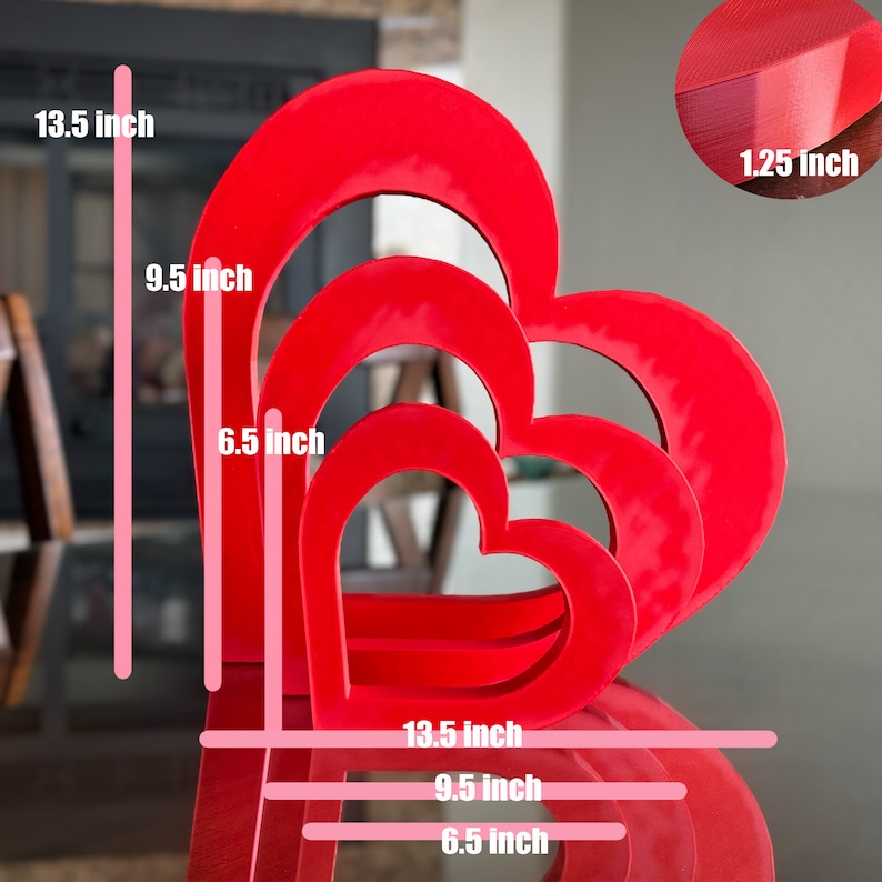 May include: Three red heart-shaped nesting boxes, the largest is 13.5 inches tall and 9.5 inches wide, the middle is 9.5 inches tall and 6.5 inches wide, and the smallest is 6.5 inches tall and 6.5 inches wide. The boxes are made of a thick, sturdy material and have a smooth, glossy finish.