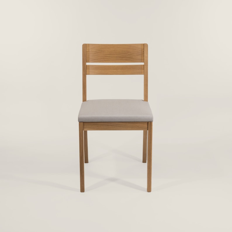 May include: A wooden chair with a light gray fabric seat and a slatted back.