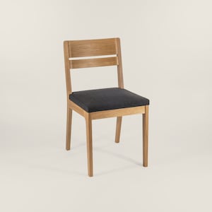 May include: A wooden chair with a dark gray fabric seat. The chair has a simple design with a straight back and four legs.