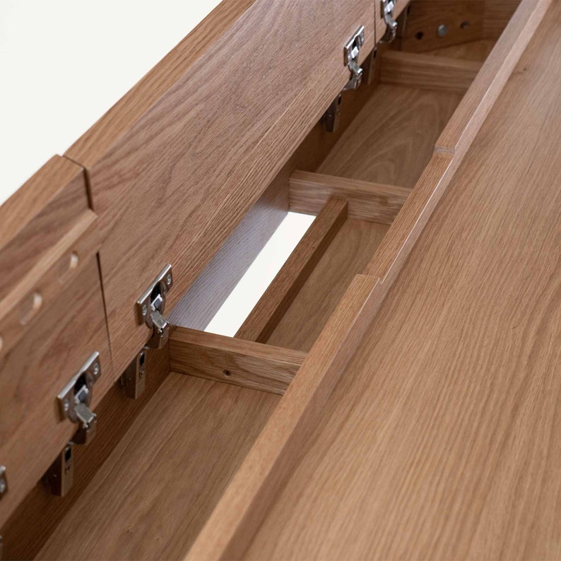 May include: A wooden table with a hidden compartment that opens to reveal a series of smaller compartments. The compartments are lined with wood and have hinges.