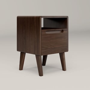 May include: A dark brown wooden nightstand with a single drawer and a shelf. The nightstand has four legs and a rounded front edge.