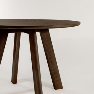 May include: A dark brown wooden table with a round top and four legs. The table is made of solid wood and has a natural finish.
