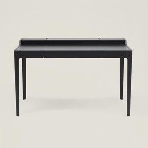 May include: A black desk with a rectangular top and four legs. The desk has a drawer on each side and a small compartment on the top.