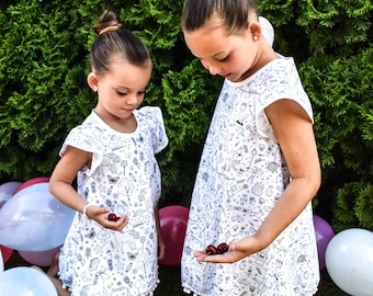 Robe de fille blanche à colorier à partir de divers tissus pour la peinture, avec des motifs comme des licornes, des princesses, des contes de fées, des bonbons et des lapins