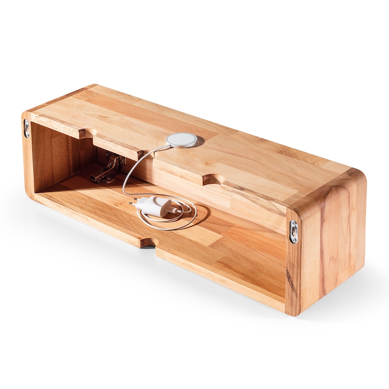 May include: A wooden wall shelf with a hidden compartment and a cut-out for a wireless charger. The shelf is made of light wood and has a rounded edge.