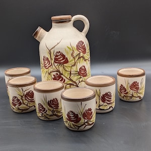 Vintage glazed terra cotta beverage decanter and cups/set. Hand painted pine cone motif.