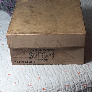 May include: A brown cardboard box with a label that reads "Ferguson's "Slip Easy" Brand Calnagar".