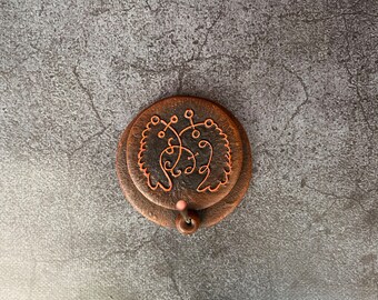 May include: A brown ceramic incense holder with a decorative design and a small incense stick inserted into the top.