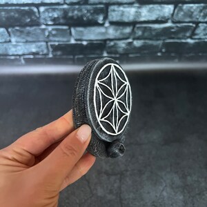 May include: A gray ceramic incense burner with a white geometric design. The burner has a small hole on the side for incense sticks.