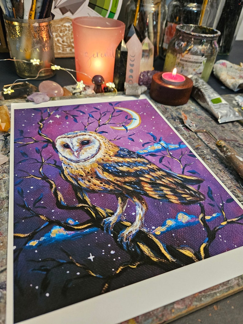 May include: A painting of a barn owl perched on a branch with a crescent moon in the background. The owl is depicted in shades of brown, white, and gold, with a purple sky filled with stars. The painting has a whimsical and magical feel.